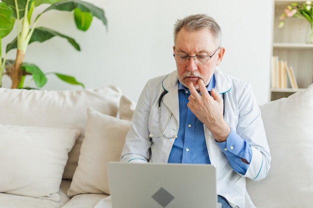 Photo senior man doctor working with laptop computer professional senior mature healthcare expert