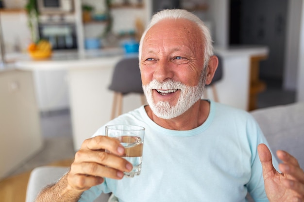 L'uomo anziano beve l'acqua dal vetro stile di vita in buona salute