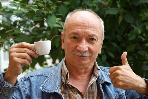 Uomo anziano che beve tazza di caffè