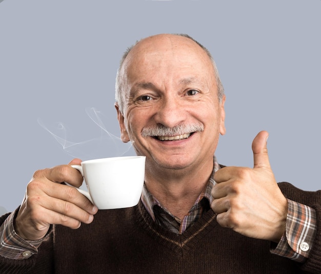 Старший мужчина пьет чашку кофе