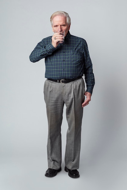 Uomo anziano che beve un bicchiere d'acqua Foto Premium