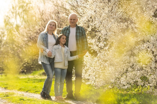 Senior man embraced by his adult daughter, outdoors.