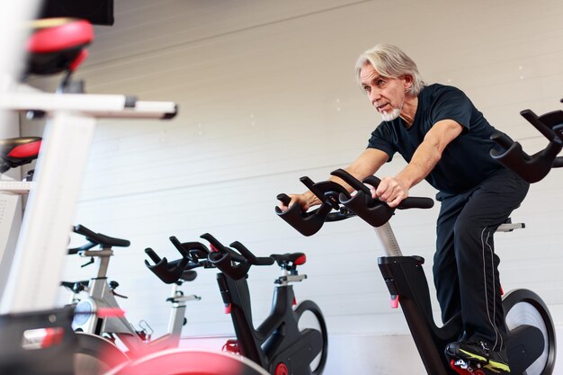 Photo senior man exercising in gym