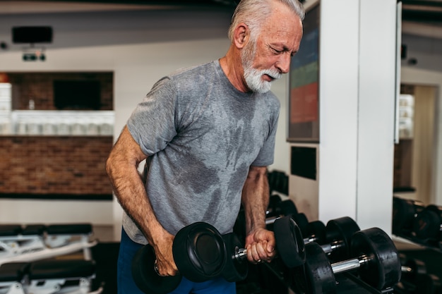 Senior man exercising at gym.