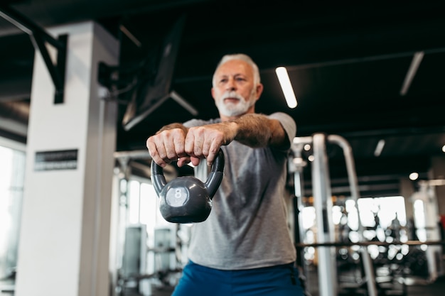 Senior man exercising at gym.