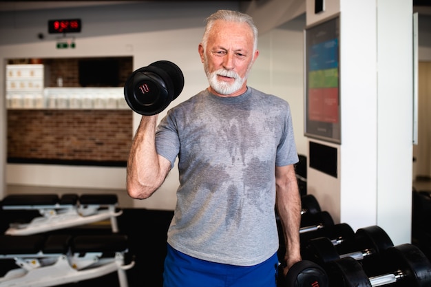 Senior man exercising at gym.