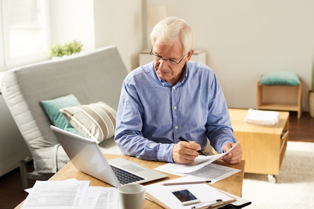 Senior Man Filing Tax Report at Home