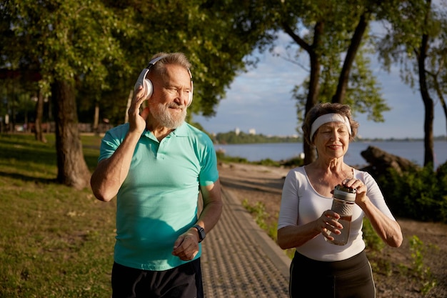 Senior man flirt met mooie oudere vrouw tijdens ochtend joggen Romantische date op outdoor training workout