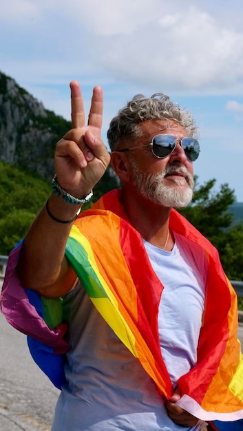 Foto uomo anziano gay dai capelli grigi con bandiera lgbt