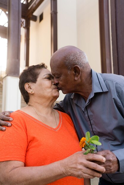 Senior man gifting flower to his wife and kissing