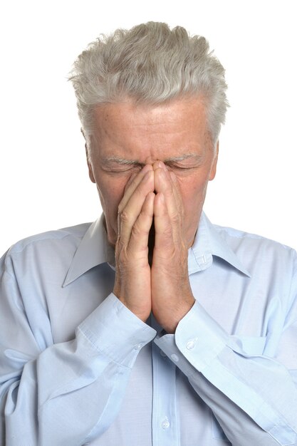 Старший мужчина страдает головной болью на белом фоне