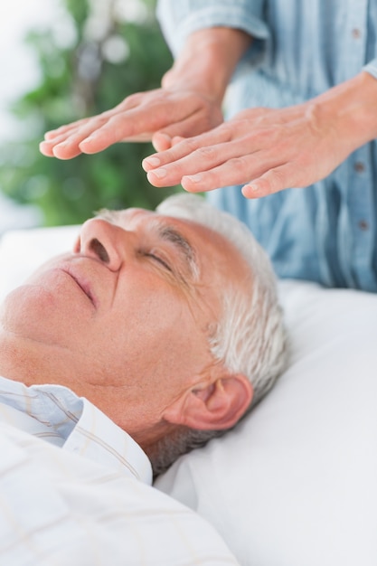 Senior man having Reiki treatment