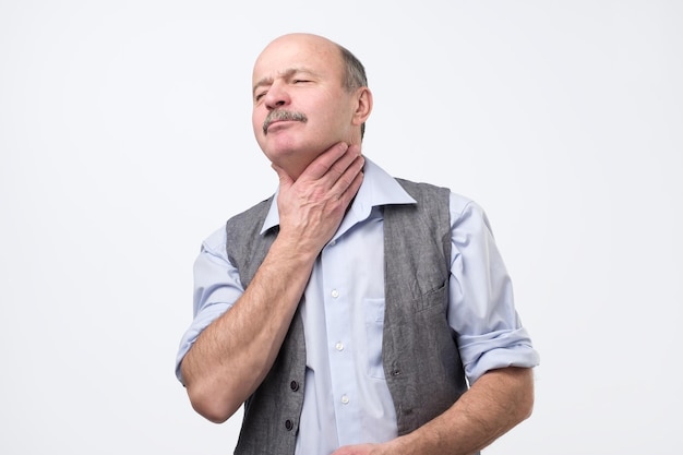 Senior man having terrible pain in throat