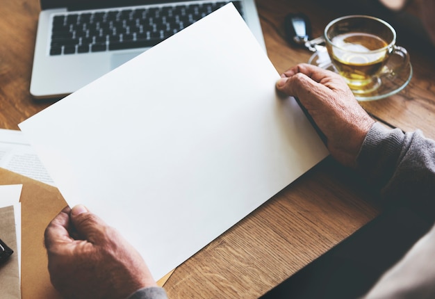 Photo senior man holding a blank paper