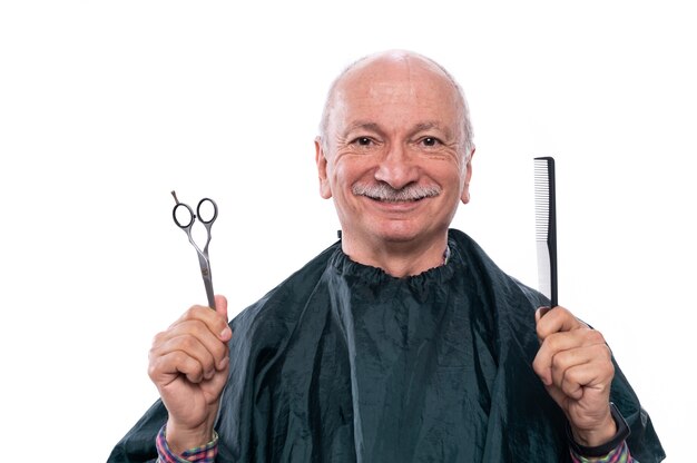 Senior man holding scissors and comb