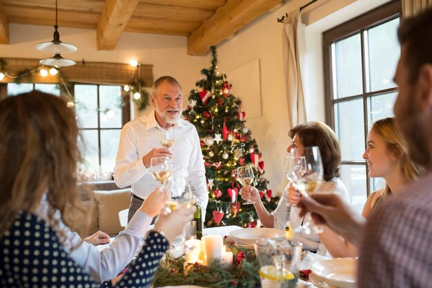 Senior man holding a speech with family at Christmas dinner