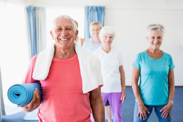 Senior man holding yoga mat