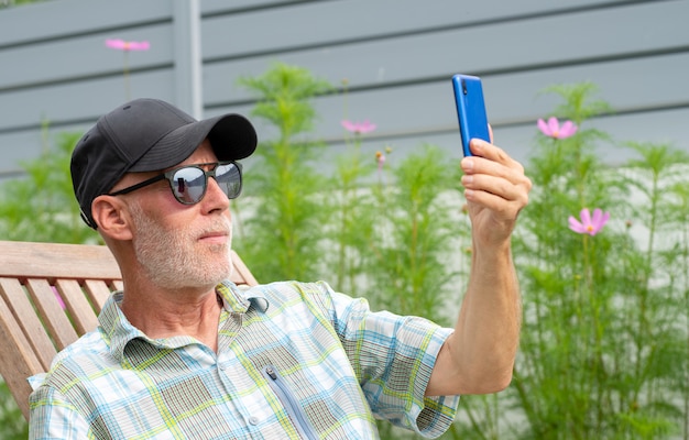Senior man in een baseball cap portret selfie maken