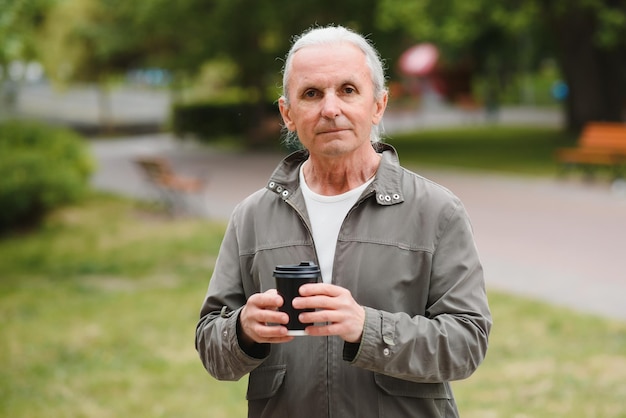 Senior man in stijlvolle outfit met kopje koffie