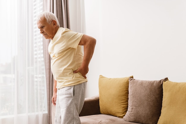 Photo senior man is suffering from pain in lower back