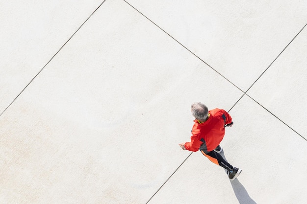 Senior man jogging along a city path Concept of healthy lifestyle Copy space Aerial view