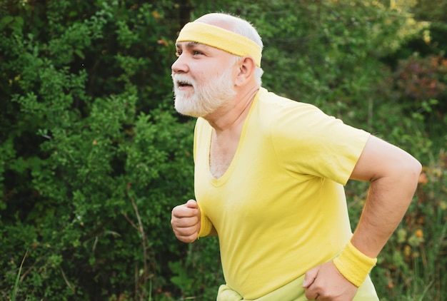 スポーツのように公園でジョギングする年配の男性面白いスポーティな古いスポーツマンがトレーニングを終えた古いスポーツママ