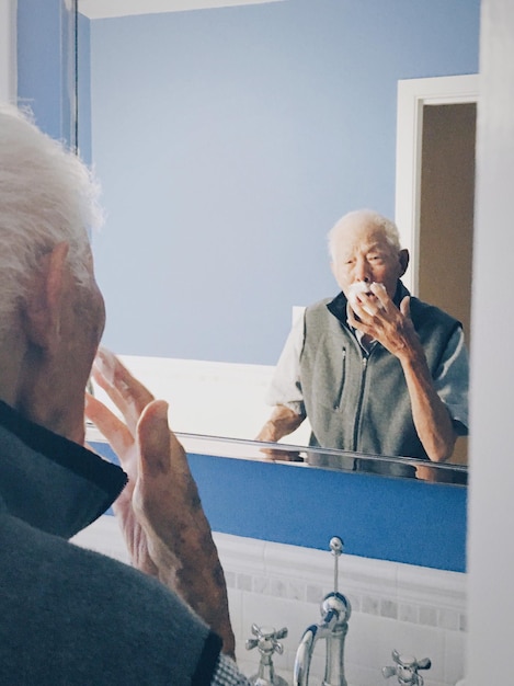 senior man looking in the mirror