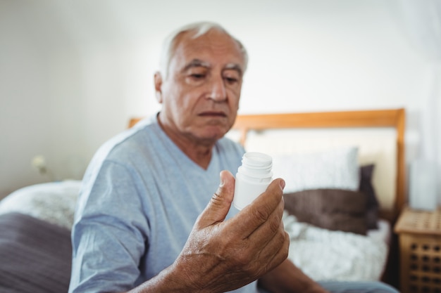 Senior man looking at pill bottle