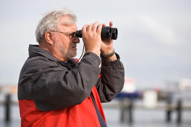 Senior man looking through binoculars