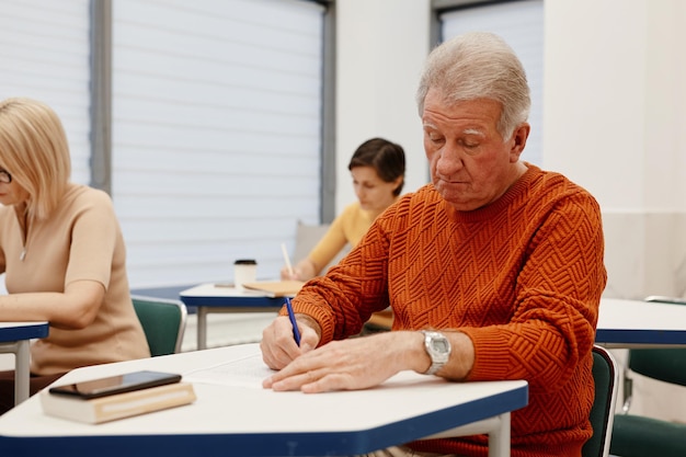 Senior man making notes at training