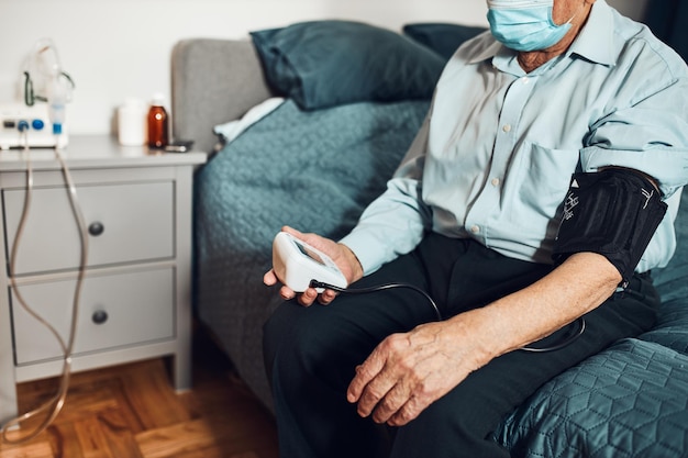 senior man measuring blood pressure and heart rate himself checking health condition elder patient