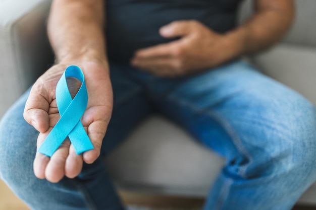 Senior man met een blauw kankerbewustzijnslint