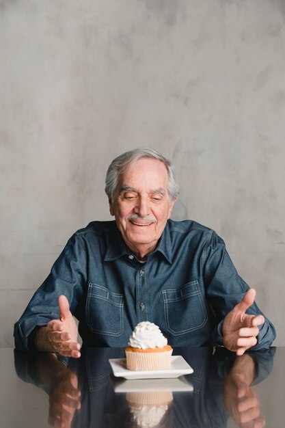 Senior man met een cupcake