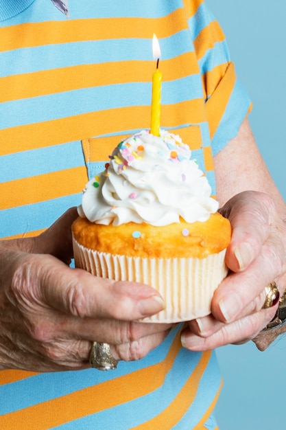 Senior man met een verjaardag cupcake