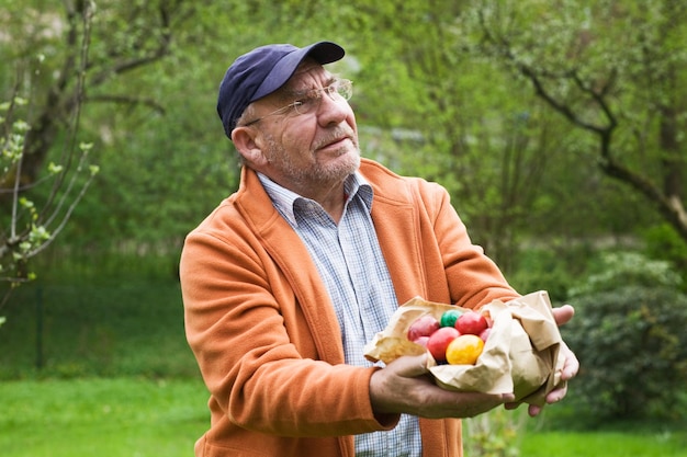 Senior man met papieren zak met paaseieren