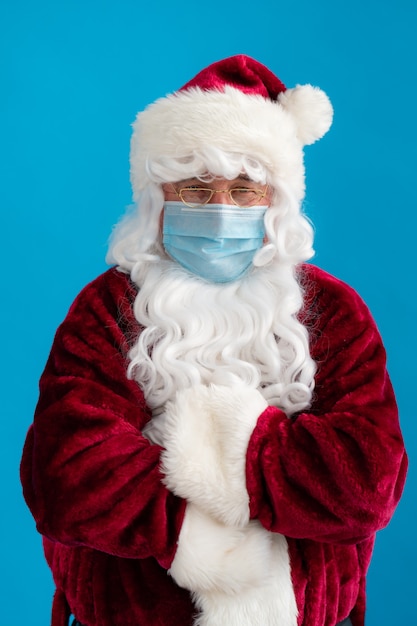 Senior man met Santa Claus-kostuum en beschermend masker. Kerstvakantie tijdens pandemisch coronavirus COVID 19-concept