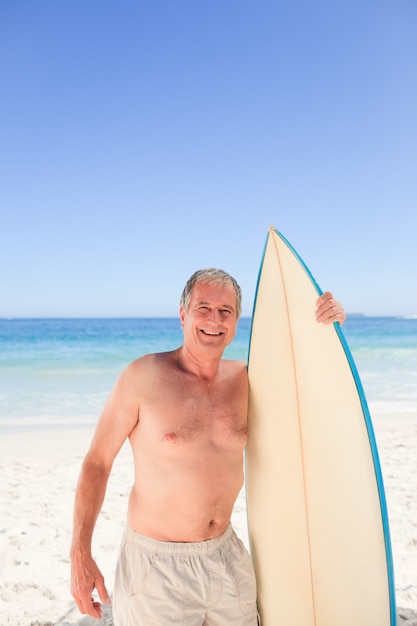 Senior man met zijn surfplank