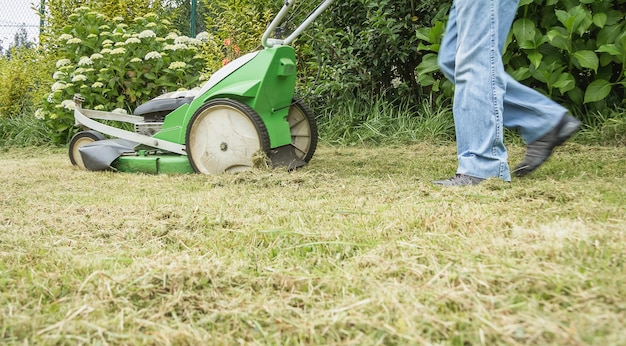 senior man mowing the lawn with a lawnmower