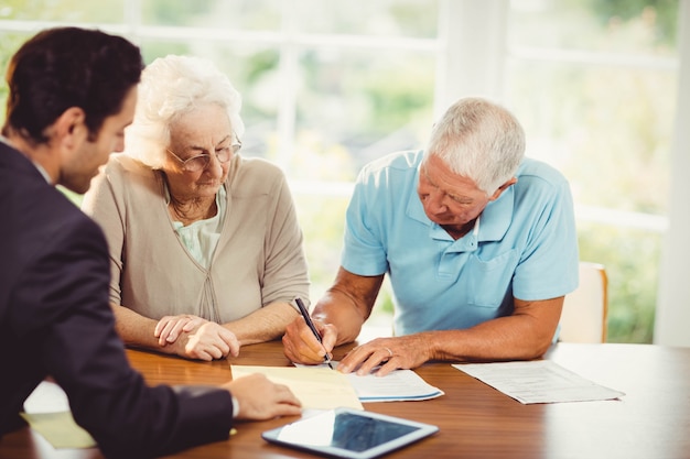 Senior man ondertekening document thuis