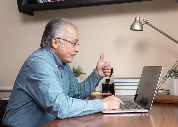 Senior man online communicatie. Oude man maakt videogesprek met familie of vrienden via de videoconferentie-app