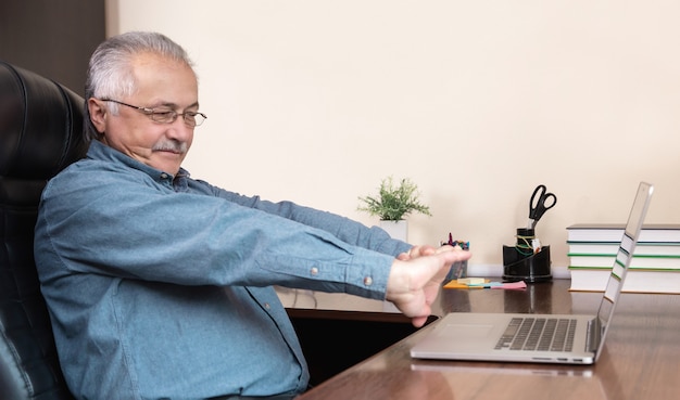 Senior man online communication. Old man makes videocall talking with relatives or friends by video conference app