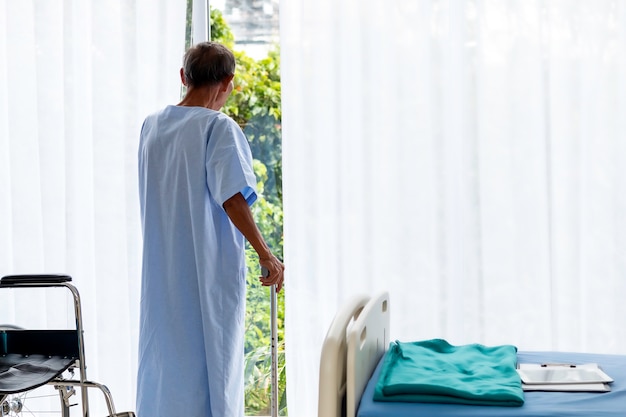 Foto senior man patiënt met wandelstok in het ziekenhuis kamer.