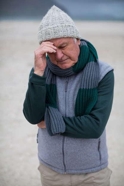 Senior man permanent op het strand