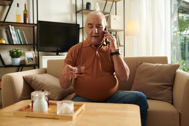 Senior man praten aan de telefoon met vriend