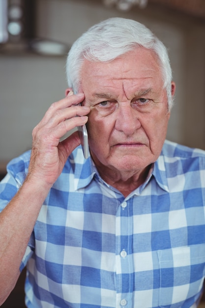 Senior man praten op mobiele telefoon