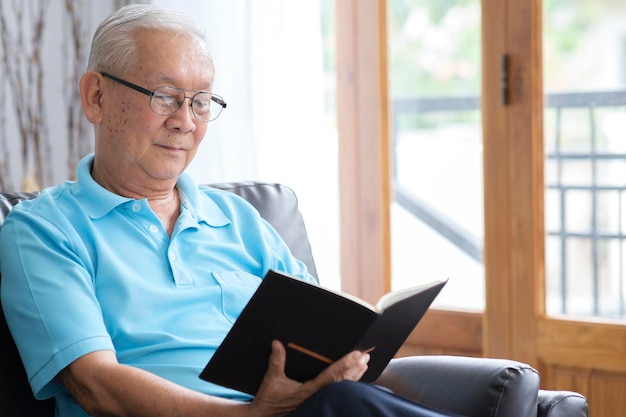 Senior man reading book and stay alone at home