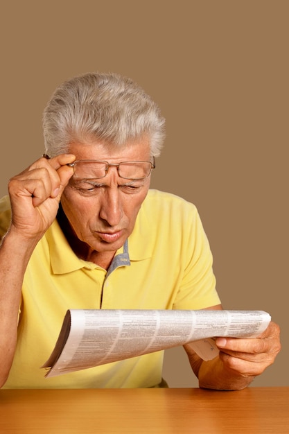 Photo senior man reading newspaper