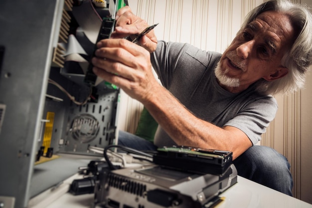 Senior man repairing equipment at home