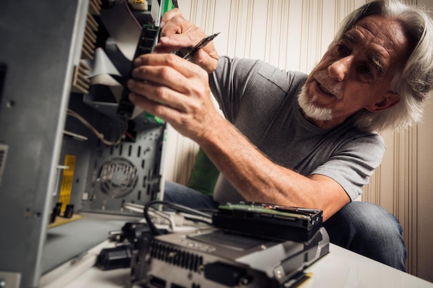 Photo senior man repairing equipment at home