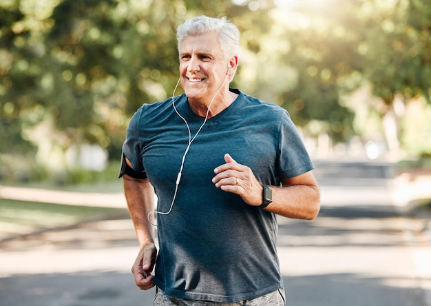 Senior man running while listening to music outdoor street and park for fitness wellness or healthy lifestyle with summer lens flare bokeh Elderly person exercise workout or jogging with earphones